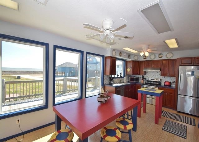 kitchen with stainless steel appliances, tasteful backsplash, ceiling fan, and light hardwood / wood-style floors