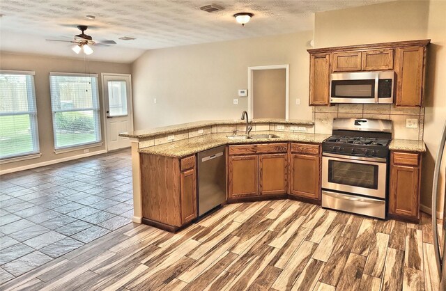 kitchen featuring tasteful backsplash, stainless steel appliances, sink, and light hardwood / wood-style flooring