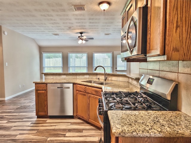 kitchen featuring a healthy amount of sunlight, appliances with stainless steel finishes, sink, and a textured ceiling