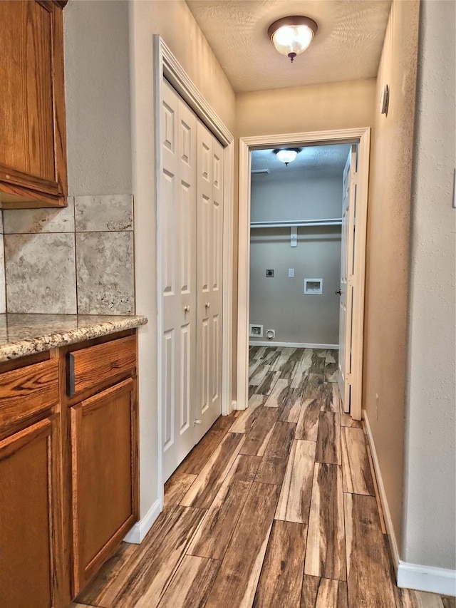 hallway with dark wood-type flooring and a textured ceiling