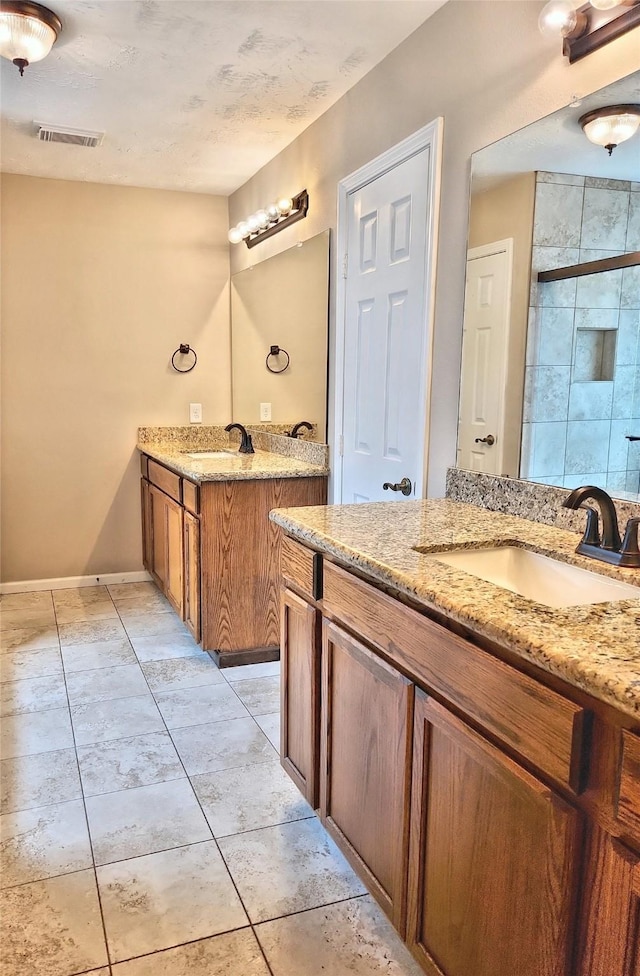 bathroom with walk in shower, vanity, and tile patterned flooring