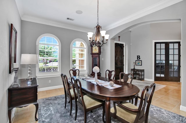 dining area with crown molding, light tile patterned floors, a notable chandelier, and french doors