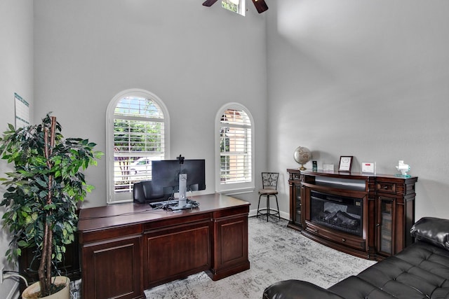 home office with ceiling fan and a high ceiling