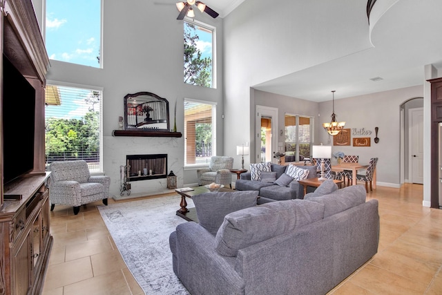 living room with an inviting chandelier, a high end fireplace, and light tile patterned floors