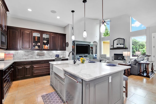 kitchen featuring dishwasher, dark brown cabinets, sink, and a kitchen island with sink