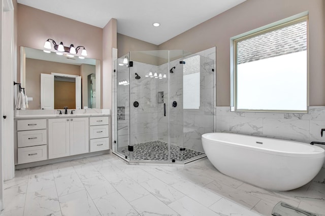 bathroom with vanity, shower with separate bathtub, and tile walls