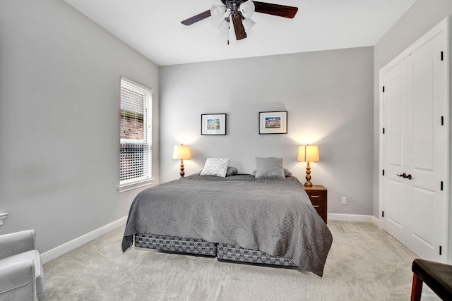 bedroom with light carpet, ceiling fan, and a closet