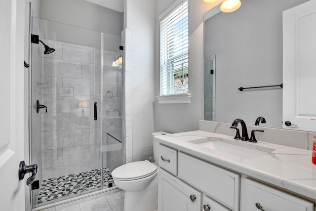 bathroom featuring tile patterned flooring, vanity, an enclosed shower, and toilet