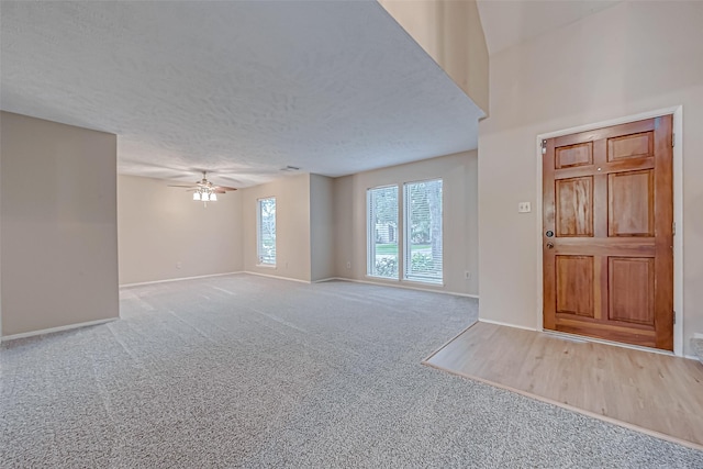 interior space featuring ceiling fan, a textured ceiling, and carpet flooring