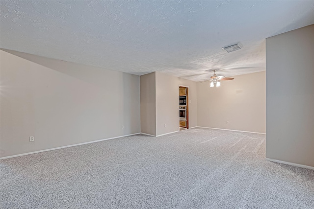 carpeted spare room featuring ceiling fan and a textured ceiling