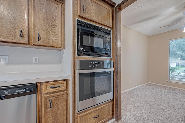 kitchen with carpet floors, appliances with stainless steel finishes, light countertops, baseboards, and ceiling fan