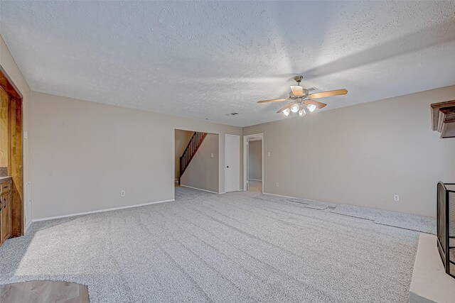 unfurnished living room with ceiling fan, light carpet, and a textured ceiling