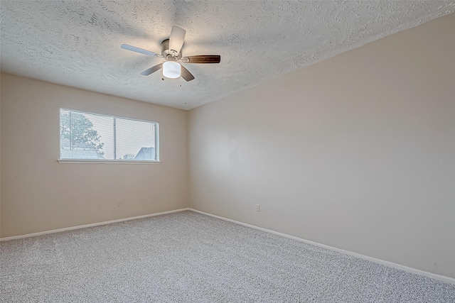 carpeted spare room featuring a textured ceiling, baseboards, and ceiling fan