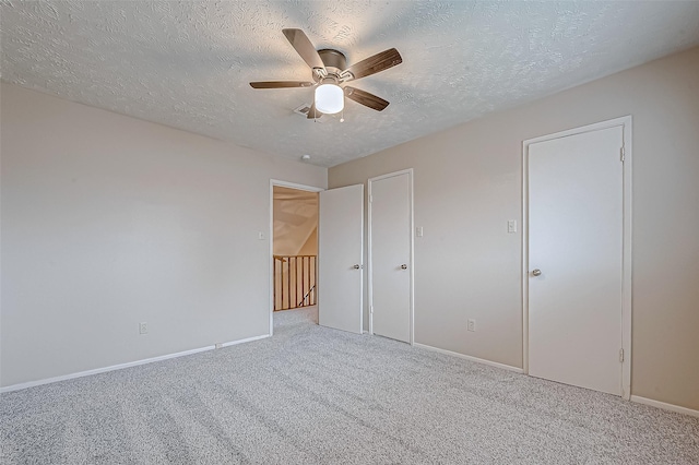 unfurnished bedroom featuring carpet, baseboards, and a textured ceiling