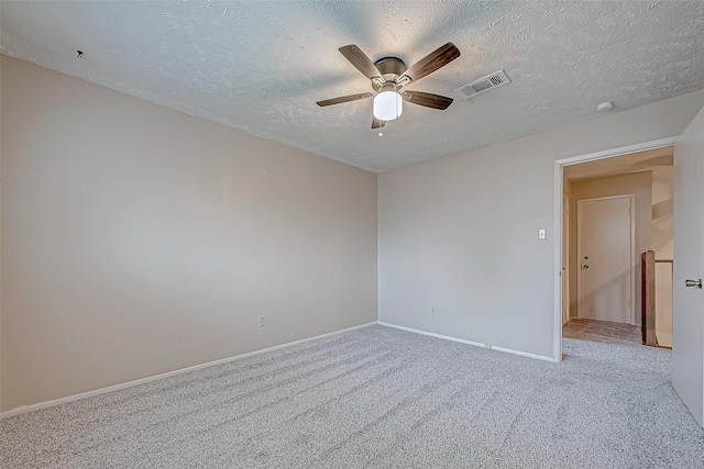 carpeted empty room featuring visible vents, ceiling fan, a textured ceiling, and baseboards