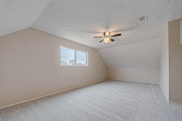 additional living space with visible vents, carpet flooring, ceiling fan, and vaulted ceiling