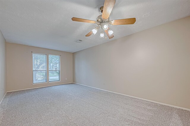 empty room featuring ceiling fan, carpet flooring, and a textured ceiling