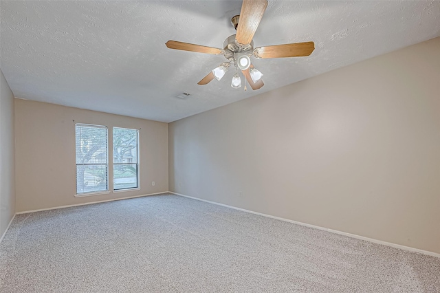 carpeted spare room with visible vents, baseboards, and a textured ceiling