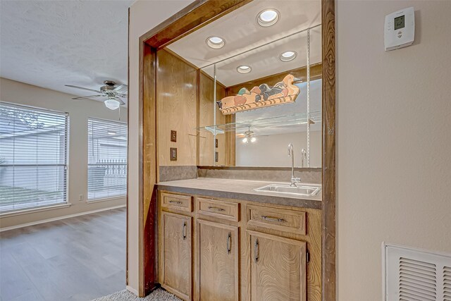 bar with ceiling fan, wood-type flooring, sink, and light brown cabinets