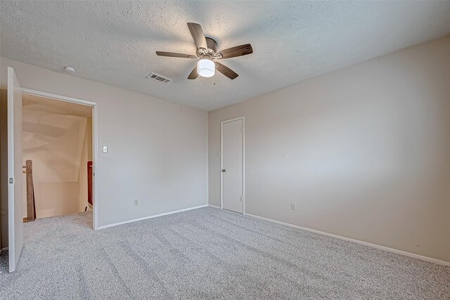 carpeted spare room featuring ceiling fan and a textured ceiling