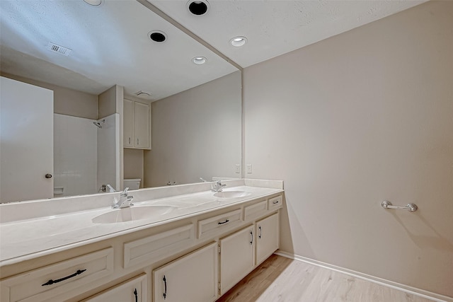 bathroom featuring wood-type flooring, vanity, and toilet