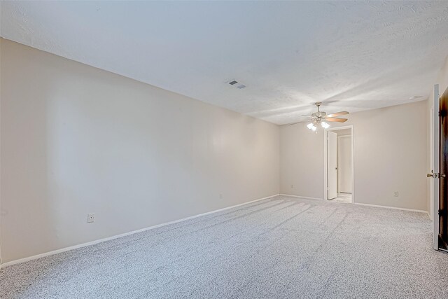 carpeted spare room with ceiling fan and a textured ceiling