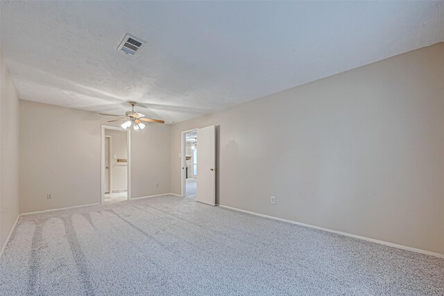 unfurnished room featuring ceiling fan, light carpet, and a textured ceiling