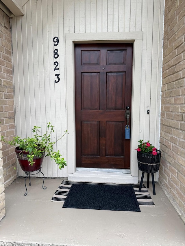 property entrance featuring brick siding