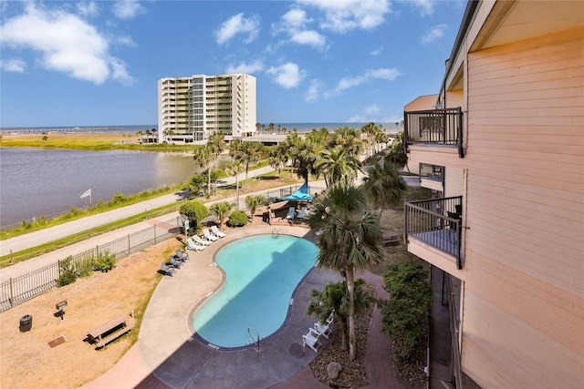 view of swimming pool featuring a patio and a water view