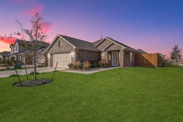 ranch-style home featuring a garage and a lawn