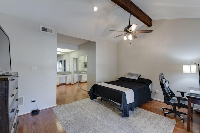 bedroom with hardwood / wood-style floors, lofted ceiling with beams, ceiling fan, and ensuite bathroom