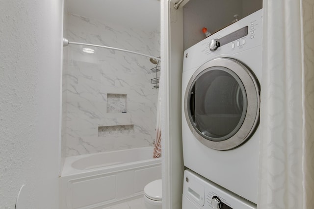 clothes washing area featuring stacked washer and dryer