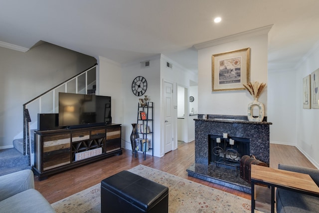 living room with crown molding, hardwood / wood-style flooring, and a fireplace