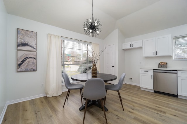 dining area with lofted ceiling, a chandelier, and light hardwood / wood-style floors