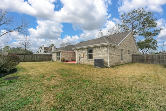 back of property with a yard and central air condition unit