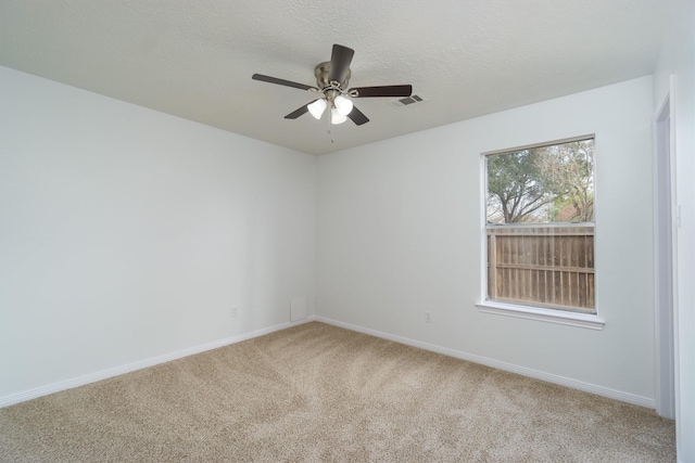 unfurnished room with ceiling fan, carpet, and a textured ceiling