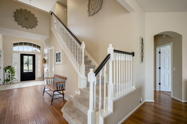 19106 High Canyon Ln, Tomball, TX 77377 - foyer entrance with a towering ceiling, wood-type flooring, arched walkways, stairs, and baseboards