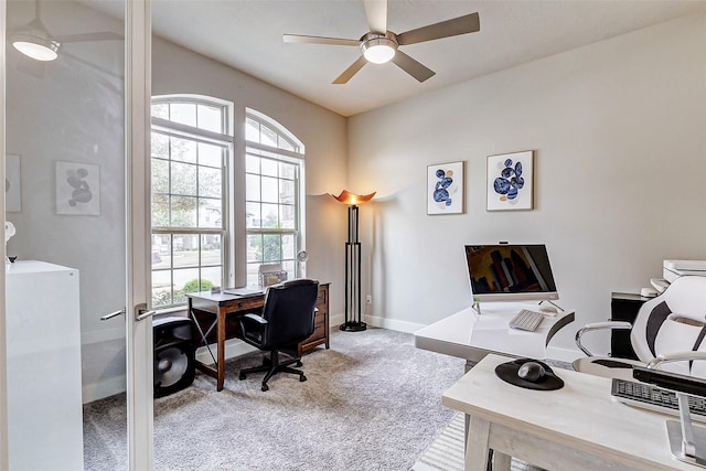 carpeted office space with ceiling fan