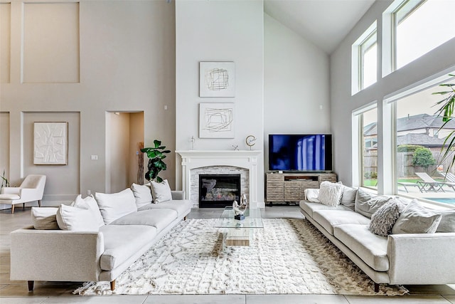 living room featuring a premium fireplace, light hardwood / wood-style floors, and high vaulted ceiling