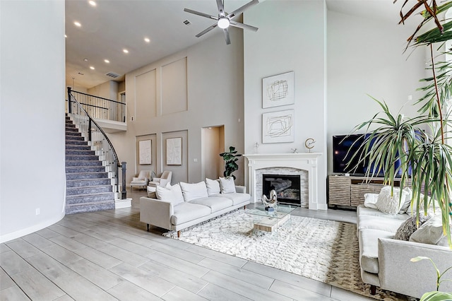 living room featuring ceiling fan and a high ceiling