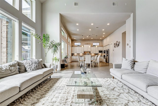 living room featuring a high ceiling and light hardwood / wood-style floors