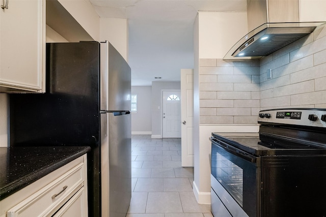 kitchen with light tile patterned flooring, extractor fan, tasteful backsplash, appliances with stainless steel finishes, and dark stone counters