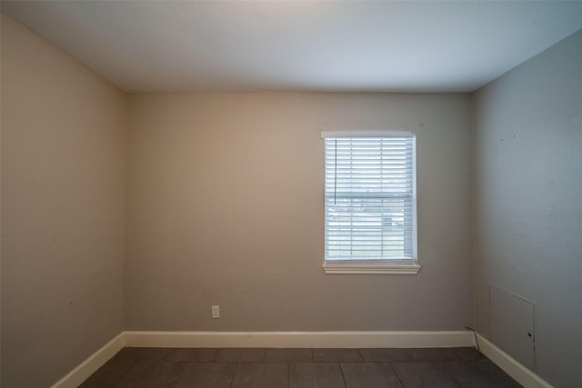 spare room featuring dark tile patterned flooring