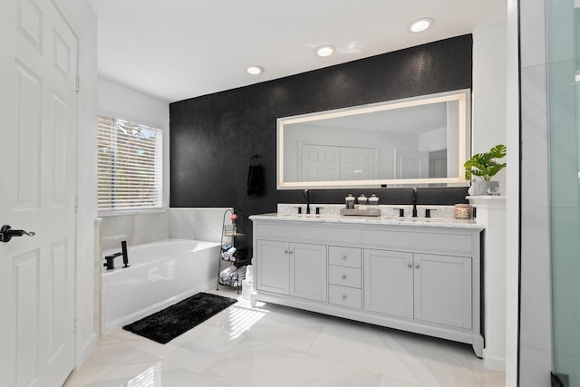 bathroom featuring tile patterned floors, vanity, and a bath