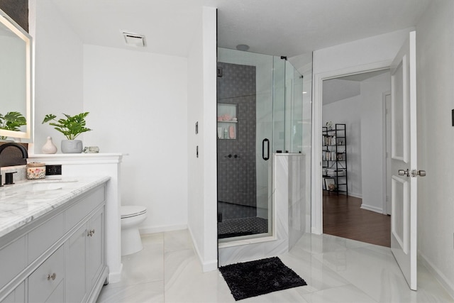 bathroom featuring vanity, toilet, and an enclosed shower