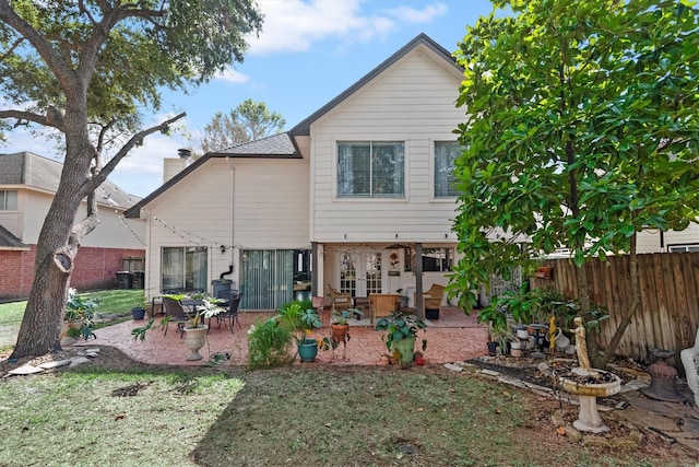 rear view of property featuring a lawn and a patio