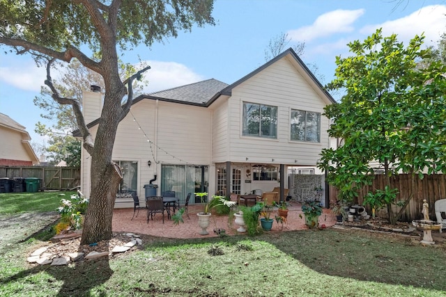 back of property with a patio and a lawn