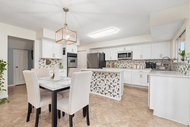 tiled dining space featuring sink and a chandelier