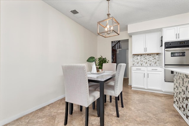 dining area with an inviting chandelier and a textured ceiling