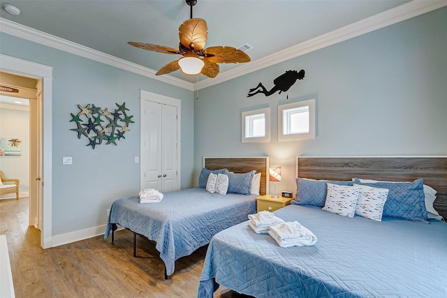 bedroom featuring crown molding, ceiling fan, hardwood / wood-style floors, and a closet